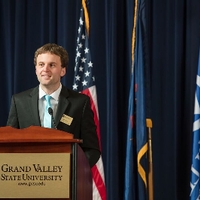 GSA member speaking to the audience from a GVSU podium